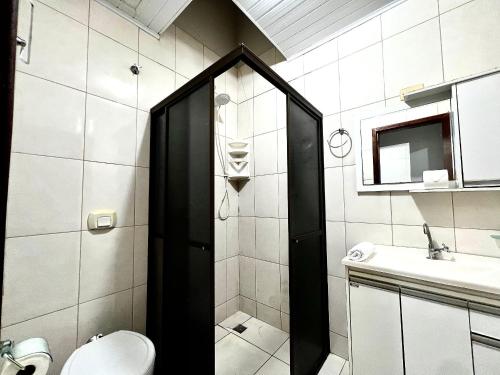 Un baño con ducha, inodoro y lavabo. en Casa Jardim Cataratas na região dos Atrativos, en Foz do Iguaçu