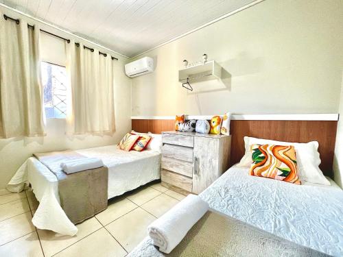 Un dormitorio con dos camas y una ventana. en Casa Jardim Cataratas na região dos Atrativos, en Foz do Iguaçu