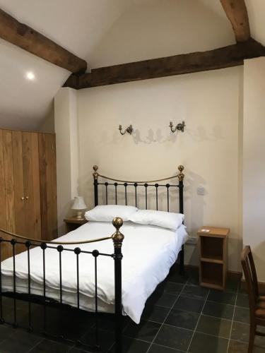 - une chambre avec un lit noir et des draps blancs dans l'établissement Nuneaton - Cottage - Sleeps 2 - Parking - Garden, à Nuneaton