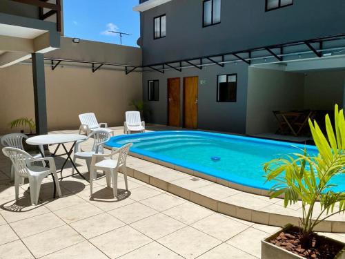 uma piscina com cadeiras e uma mesa e uma mesa e cadeiras em Hotel Pousada Alagoana em Maceió