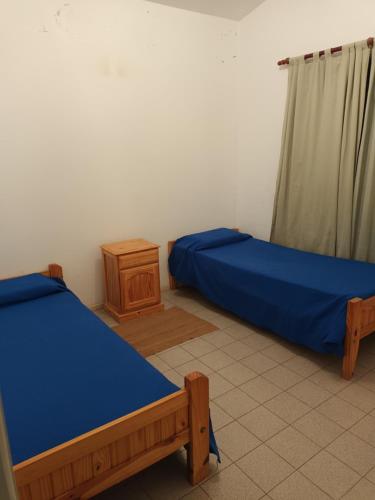 ein Schlafzimmer mit 2 Betten und einer Kommode darin in der Unterkunft Casa Los Lapachos in La Punta