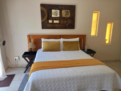 a bedroom with a large bed with two night stands at BUTRIN GUEST HOUSE in Welkom
