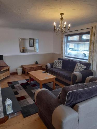 a living room with a couch and a table at Quiet 3 bed close to the A1 in Newton Aycliffe