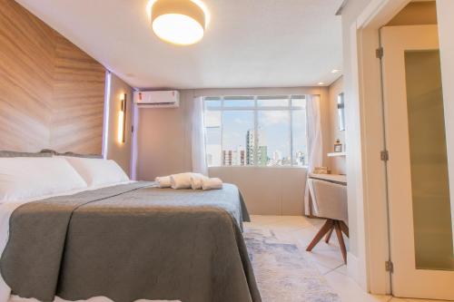 1 dormitorio con cama y ventana en Delupo Apart Hotel, en Criciúma