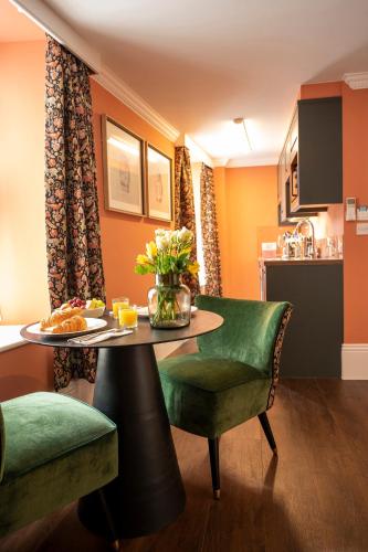 a room with a table and chairs and a kitchen at The Fanny Talbot in Barmouth