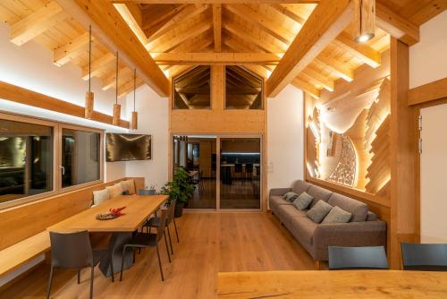 a dining room and living room with wooden ceilings at Casera Cal De Mez- Wellness Chalet 