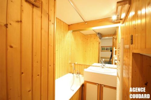 a bathroom with two sinks and a tub at Studio classé 4 personnes face aux Thermes, avec coin nuit in Le Mont-Dore