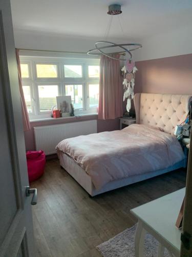 a bedroom with a bed and a table and windows at Welcoming Childwall Towers in Childwall