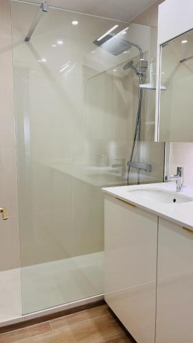 une salle de bain blanche avec une douche et un lavabo dans l'établissement le meilleur de Cannes au palm beach, à Cannes