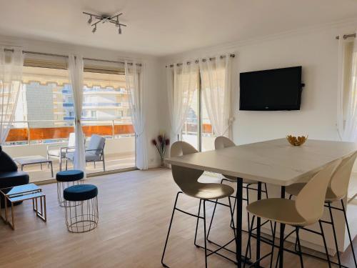 ein Wohnzimmer mit einem Esstisch und Stühlen in der Unterkunft le meilleur de Cannes au palm beach in Cannes