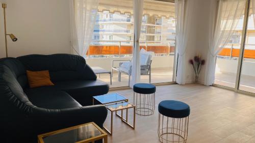 ein Wohnzimmer mit einem Sofa und einem Tisch in der Unterkunft le meilleur de Cannes au palm beach in Cannes