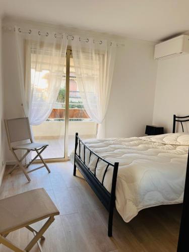 ein Schlafzimmer mit einem Bett und einem großen Fenster in der Unterkunft le meilleur de Cannes au palm beach in Cannes