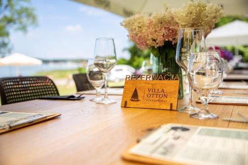 a wooden table with wine glasses and a vase of flowers at OTTON-Charzykowy Bed&Restaurant in Chojnice