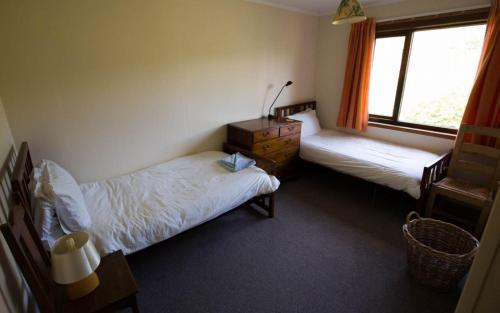 a bedroom with two beds and a window at Allt Slapin in Torrin