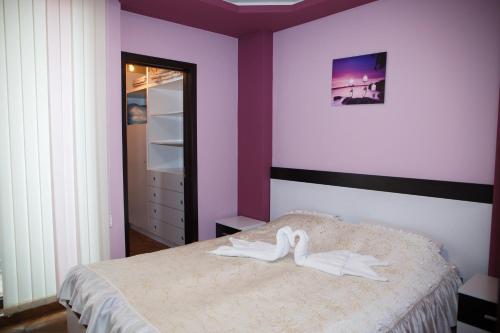 a bedroom with a bed with white shoes on it at Apartment Ira in Velingrad
