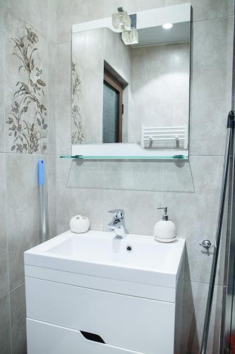 a bathroom with a white sink and a mirror at Apartment Ira in Velingrad