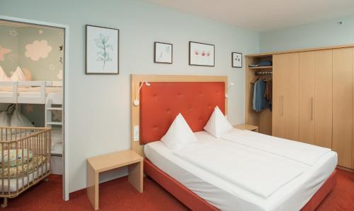a bedroom with a large bed and a crib at Hotel Sonnenpark & Therme included - auch am An- & Abreisetag! in Lutzmannsburg
