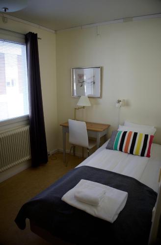 a bedroom with a bed and a desk and a window at STF Malmfältens Folkhögskola in Kiruna
