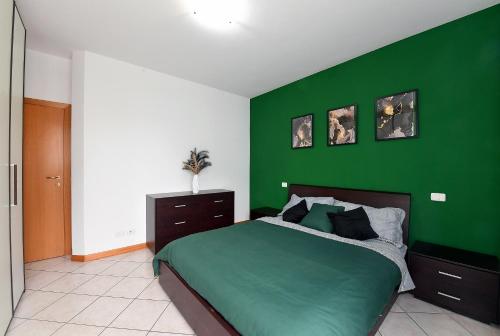- une chambre verte avec un lit et un mur vert dans l'établissement Evergreen: tra mare e natura, à Cesenatico