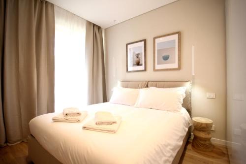 ein Schlafzimmer mit einem weißen Bett mit zwei Handtüchern darauf in der Unterkunft Mediterraneo in Bordighera