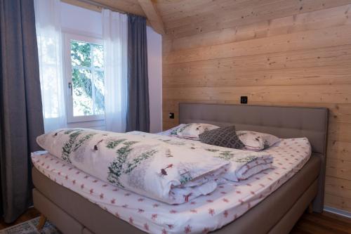 1 dormitorio con 1 cama con pared de madera en Ferienwohnung, en Staldenried