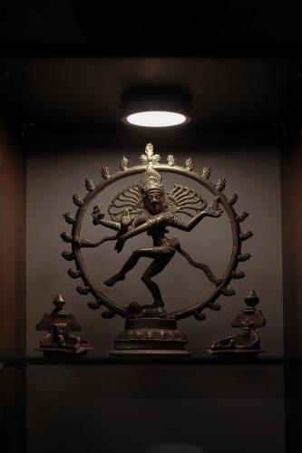 a bronze clock on a shelf in a room at NALINAM HOMESTAY in Trivandrum