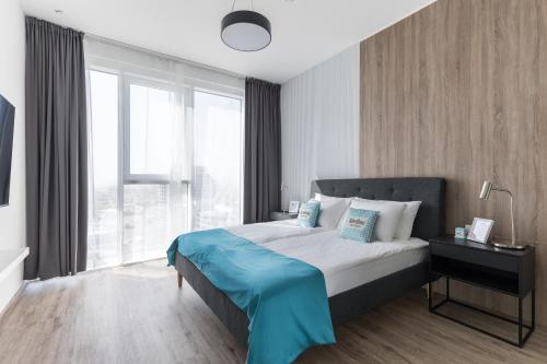 a bedroom with a bed and a large window at Revelton Apartment One Residence in Dubai