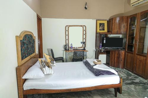 een slaapkamer met een bed met een spiegel en een tv bij NALINAM HOMESTAY in Trivandrum