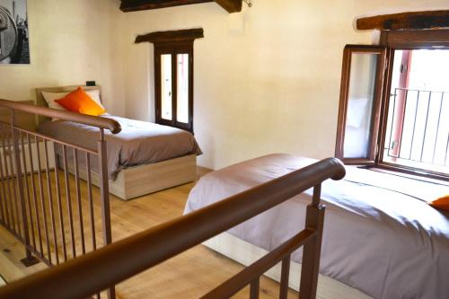 a bedroom with two beds and a staircase with a window at Residence Porta Della Muda in Vittorio Veneto