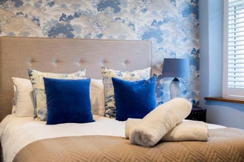 a bedroom with a bed with blue and white pillows at Sleepers Barn in Saint Teath