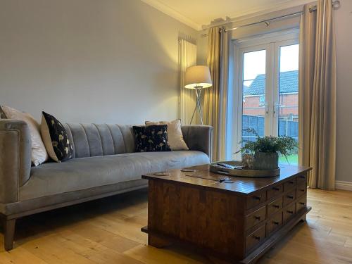 a living room with a couch and a coffee table at Modern house easy access Norwich city and broads in Spixworth