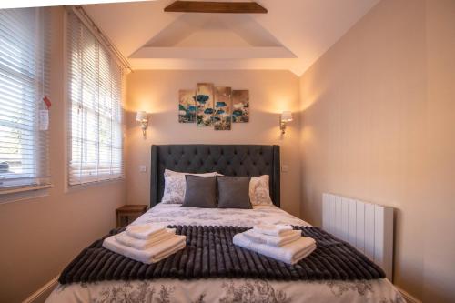 1 dormitorio con 1 cama con 2 toallas en Luxury 1 bed studio at Florence House, in the centre of Herne Bay and 300m from beach en Herne Bay