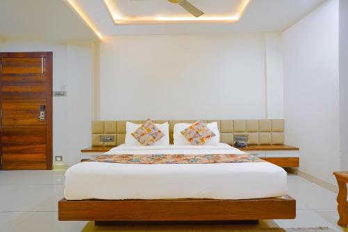 a bedroom with a large bed with white walls at FabHotel Jewel Palace in Bhopal