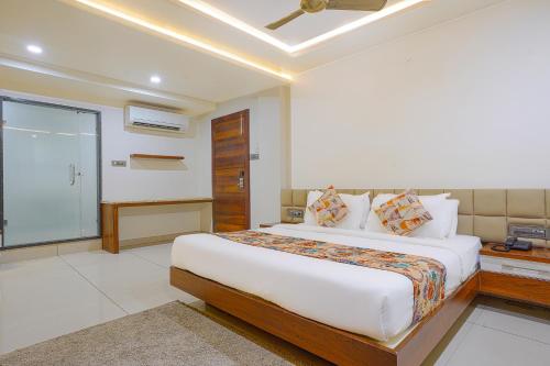 um quarto com uma cama grande e uma janela em FabHotel Jewel Palace em Bhopal