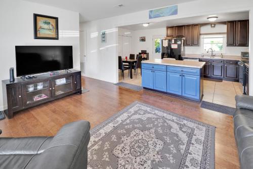 ein Wohnzimmer mit einem Sofa und einem TV sowie eine Küche in der Unterkunft Jewell Cottage in Port Saint Joe