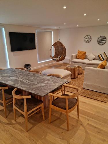 a living room with a table and chairs and a couch at Island Club by Smart City Stays in Cape Town