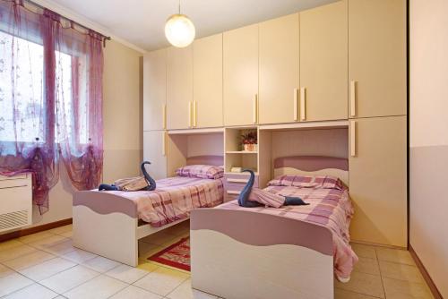 - 2 lits dans une chambre avec des armoires dans l'établissement App Al Signorino Lake Bellagio, à Lezzeno