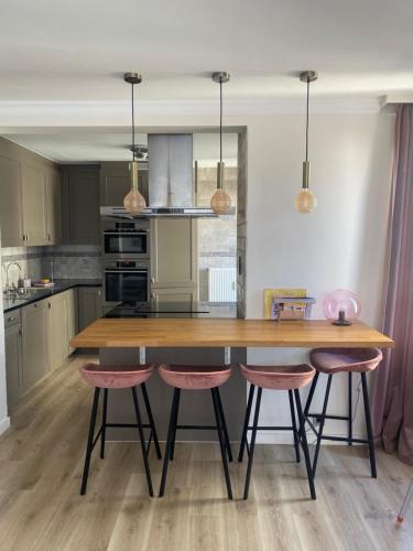 een keuken met een houten tafel en 2 krukken bij Portofino - luxe appartement met lateraal zeezicht in Oostende