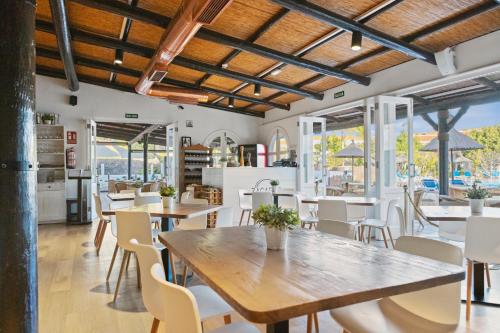 a dining room with tables and chairs and windows at Wyndham Residences Golf del Sur in San Miguel de Abona
