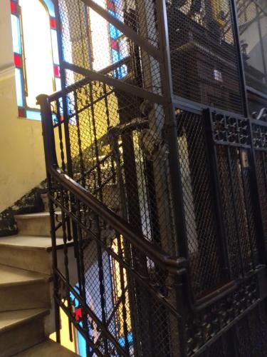 een trap met een smeedijzeren leuning en een glas-in-loodraam bij B&B Amarantha Gothica Genoa in Genua