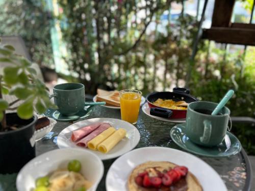 a table with plates of food and cups of coffee at Casona Lorena in Santiago