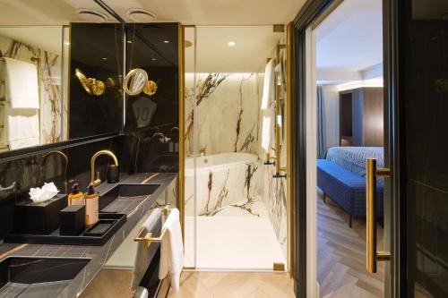 a bathroom with a tub and a sink and a shower at Hotel MIM Andorra in Escaldes-Engordany