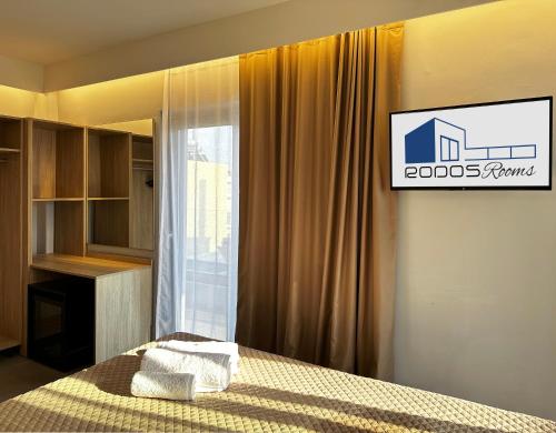 a bedroom with a bed and a sign on the wall at Rodosrooms in Rhodes Town