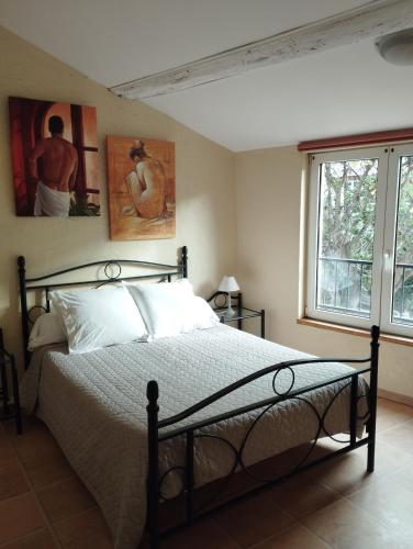 a bedroom with a bed and two paintings on the wall at Aux Berges du Canal in Capestang