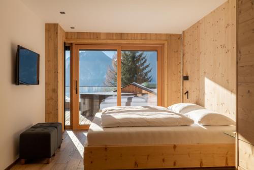 a bedroom with a bed and a large window at Chalet Residenz Zillertal Mühlermoos in Ramsau im Zillertal