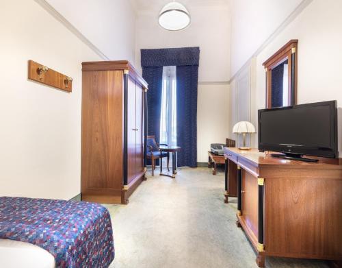 a bedroom with a bed and a flat screen tv at Hotel Palace Bologna Centro in Bologna
