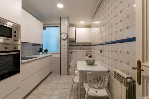 a kitchen with a table and a clock on the wall at Amama apartment by People Rentals in Bilbao
