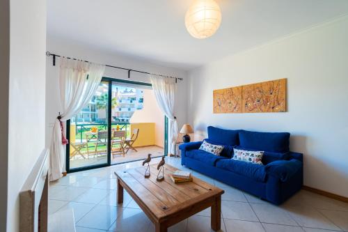 uma sala de estar com um sofá azul e uma mesa em Beach House Santa Eulália, Albufeira em Albufeira