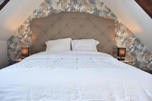 une chambre avec un lit blanc et deux lampes dans l'établissement Blaz an Holen - Maison avec jardin à Guimaëc, à Saint-Jean-du-Doigt