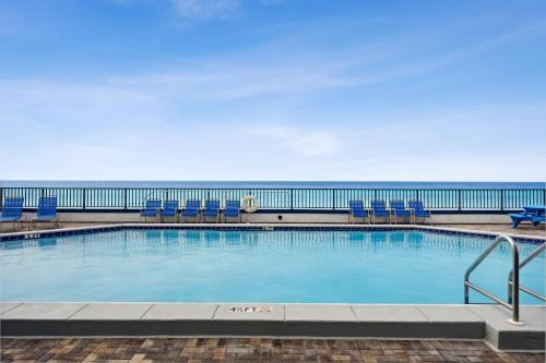 basen z krzesłami i ocean w tle w obiekcie AquaVista Beach Resort by Panhandle Getaways w mieście Panama City Beach